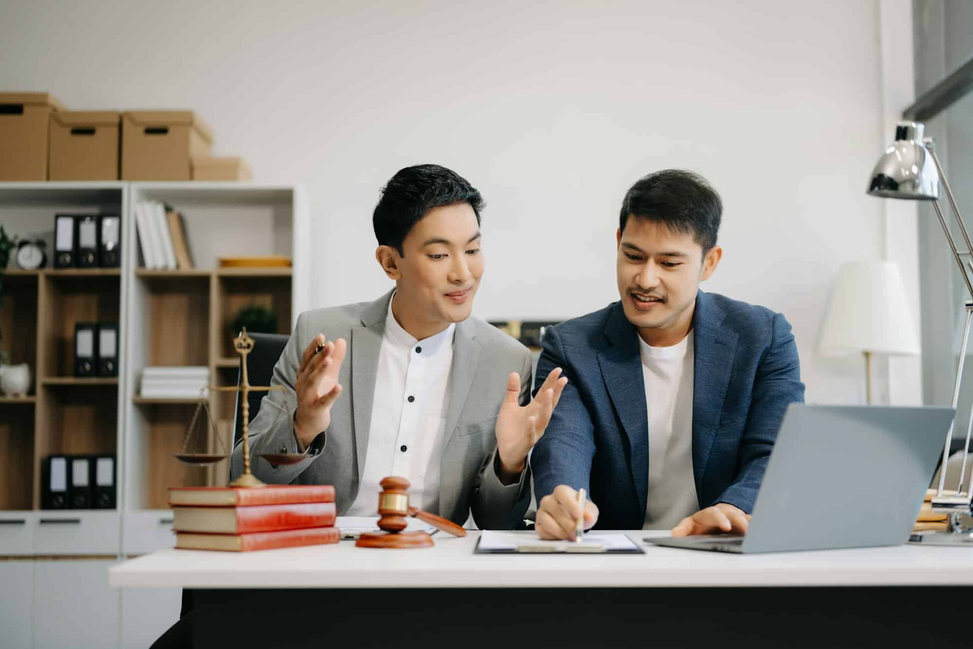 Asian business team and lawyers discussing contract papers sitting at the table.